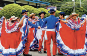 Men and women in traditional outfits dancing.