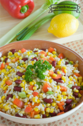 Un tazón de ensalada de cebada, frijoles y verduras adornada con perejil.