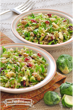 Platos de ensalada con coles de Bruselas, arándanos rojos secos y nueces mezclados con un aderezo de cítricos.