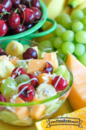 Mezcla de frutas frescas en un tazón con hojuelas de coco.