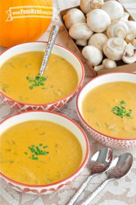 Tazones de sopa de calabaza y hongos adornados con cebollines.  