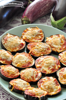 Plato de rodajas de berenjena con salsa roja y mozzarella espolvoreado con migas de pan.