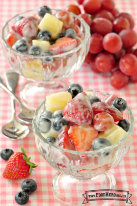 Vasos de postre rellenos con una mezcla de frutas recubierta de yogur.  