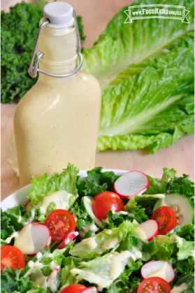 Botella de aderezo exhibida con una ensalada.