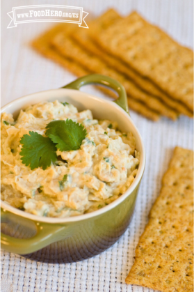 Dip de garbanzo adornado con cilantro y servido con galletas saladas.