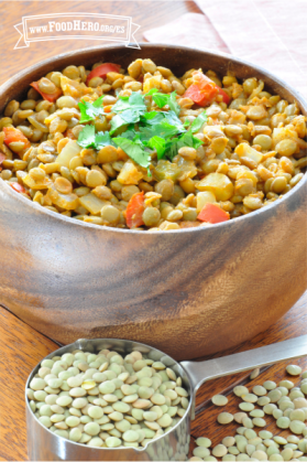 Tazón de lentejas sazonadas con verduras adornadas con cilantro.