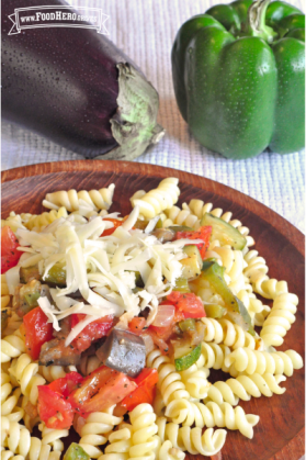 Fideos rotini con verduras y queso rallado.