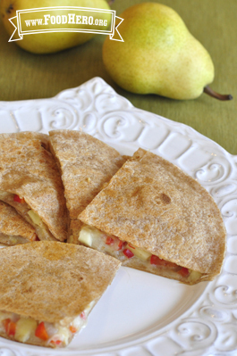 Plate of golden tortilla folded over a cheese, pear and vegetable filling.