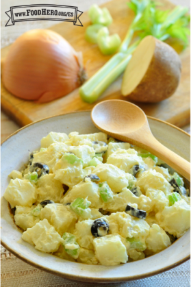 Tazón de papas, apio y aceitunas negras con un aderezo cremoso.