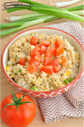 Tazón con avena con queso cubierto con tomates picados.