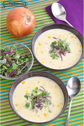 Tazones de sopa de elote cremosa adornada con micro plantas.