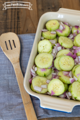 Plato con rodajas de pepino y cebolla morada sazonadas.