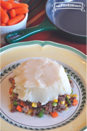 Plato con carne de res molida y verduras con una capa de puré de papa encima.