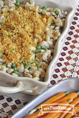 Casserole dish of creamy noodles with peas and turkey topped with crushed corn flakes.