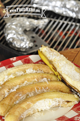 Grilled bananas topped with pineapple and shredded coconut shown on a serving platter.