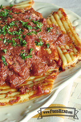 Plate of stuffed cheese pasta with red sauce and fresh parsley.