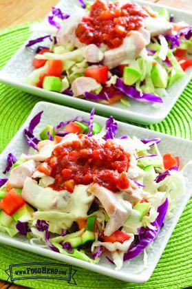 Plates with cabbage and vegetables below a fish, ranch and salsa topping.