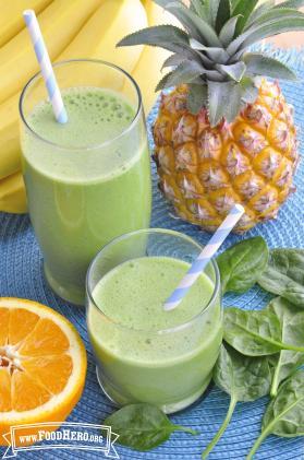 Glasses of green fruit smoothies with straws.