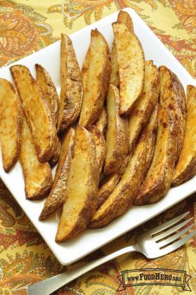 Plate of golden baked potato slices. 