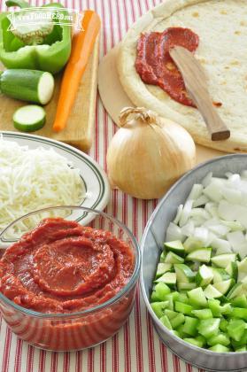 Tomato sauce blend being shown spread onto pizza dough. 