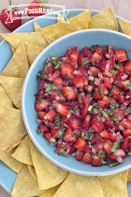 Bowl of bright green and red Strawberry Salsa served with tortilla chips. 