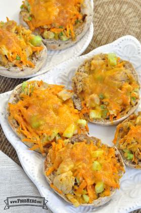 Plate of english muffins topped with a tuna mix and cheese.