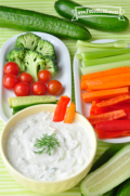 Dip de yogur servido con un plato de palitos de verduras.