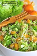 Bowl of mandarin orange and barley salad with a wooden serving fork.