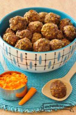 Se muestra un tazón de albóndigas horneadas hechas con avena y zanahoria rallada en un mantel individual.