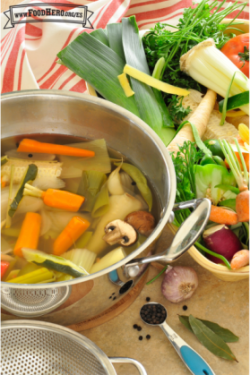 Olla llena de agua con verduras y hierbas.