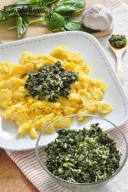 Small bowl of pesto served with scrambled eggs.