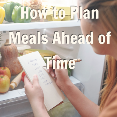 Woman looking at fridge and writing a list