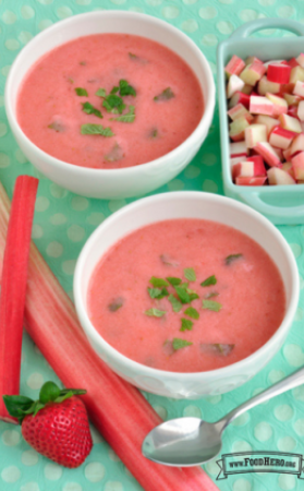 Pink fruit soup garnished with fresh mint.