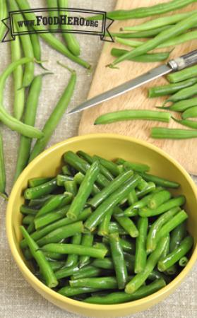 Bowl of green beans coated with sauce. 