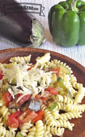 Rotini noodles with vegetables and shredded cheese.