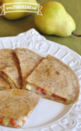 Plate of golden tortilla folded over a cheese, pear and vegetable filling.