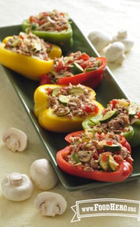 Platter of multicolored baked bell peppers stuffed with ground turkey, vegetables and mushrooms.