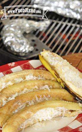 Grilled bananas topped with pineapple and shredded coconut shown on a serving platter.