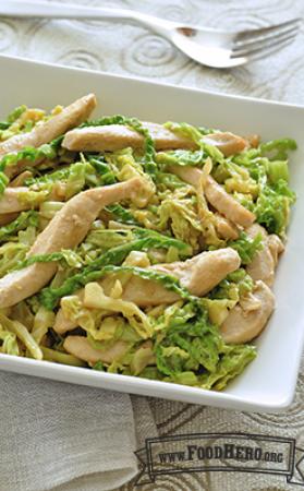 Green cabbage with strips of chicken on a plate.